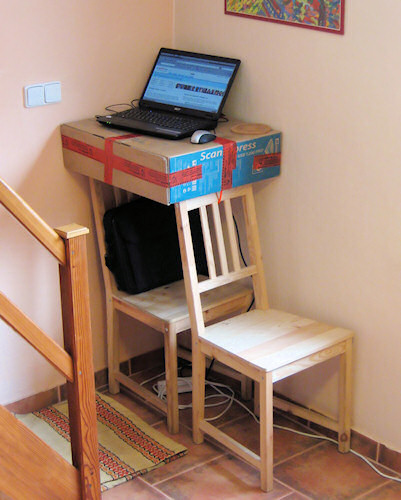 Temporary setup using a box taped on top of two chairs, to create a high laptop desk