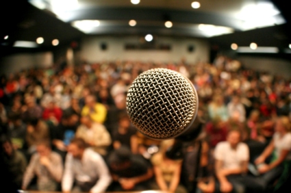 Presenter's-eye-view of microphone with audience in the background