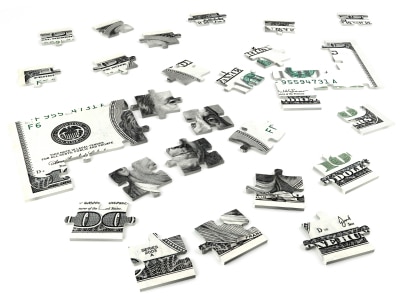 Scattered pieces of a dollar bill jigsaw