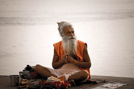 Guru siting cross-legged by a river in India