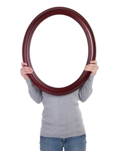 Woman holding up mirror so it covers her face