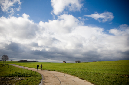 Two people walking along a path through the countryside
